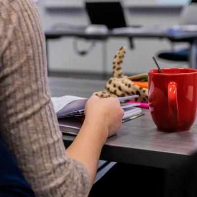 student in class with red coffee mug